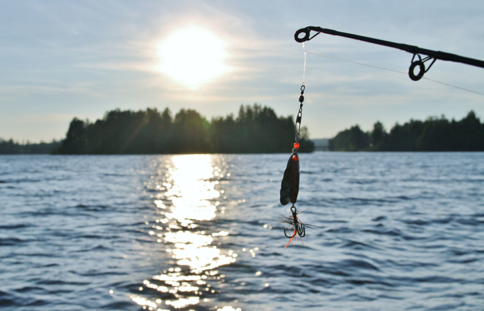 Ett fiskedrag som hänger från en båt på en sjö.