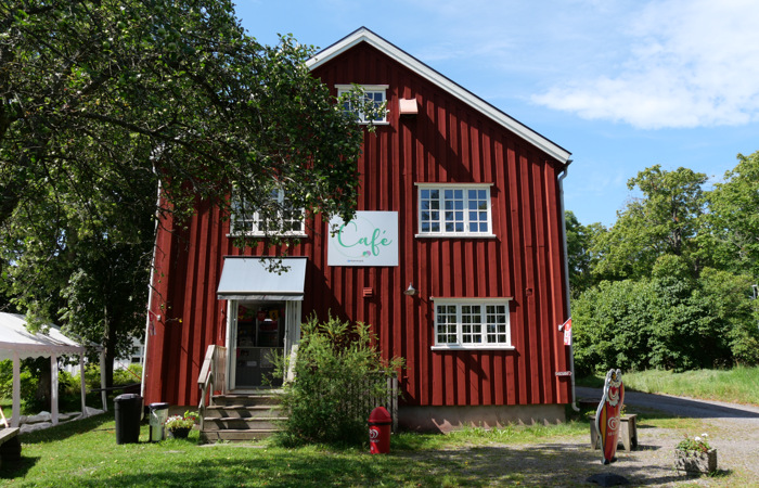 En röd byggnad med en skylt på.