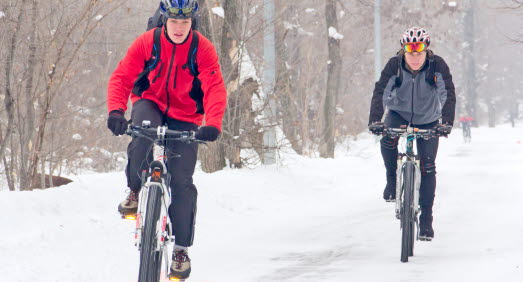 Cyklister cyklar i snön